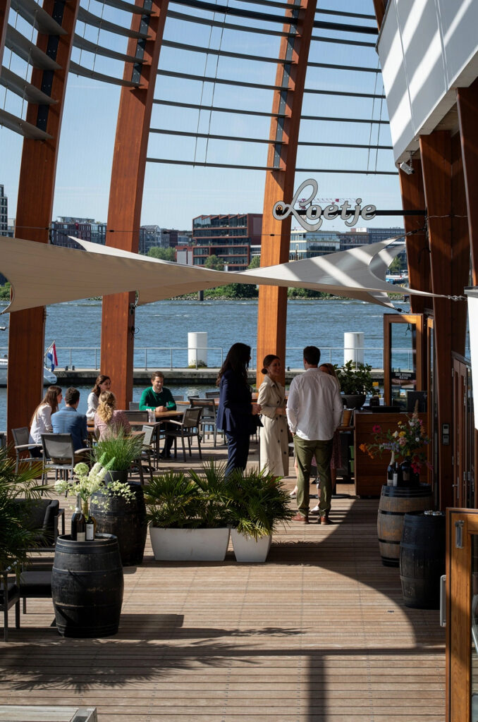 Terras van Loetje aan ’t IJ met gasten en uitzicht over het water.