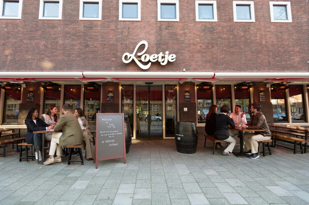 Gevel en terras van Loetje De Pijp met gasten aan tafel.