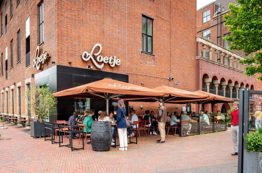 Terras van Loetje Rotterdam Blaak voor het karakteristieke bakstenen pand.
