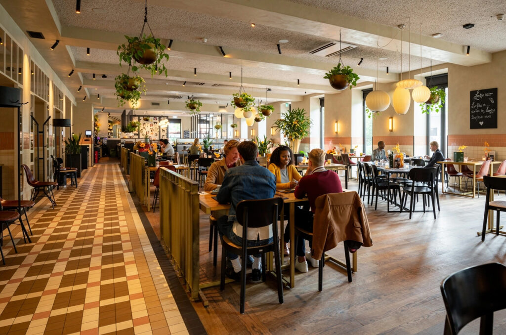 Gasten aan tafel in het ruime interieur van Loetje Rotterdam Blaak.