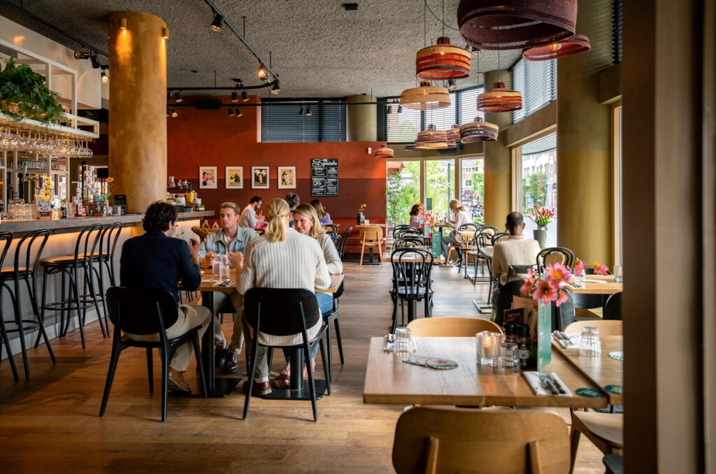 Restaurant van Loetje Zeist met gasten aan tafel en de bar aan de zijkant.