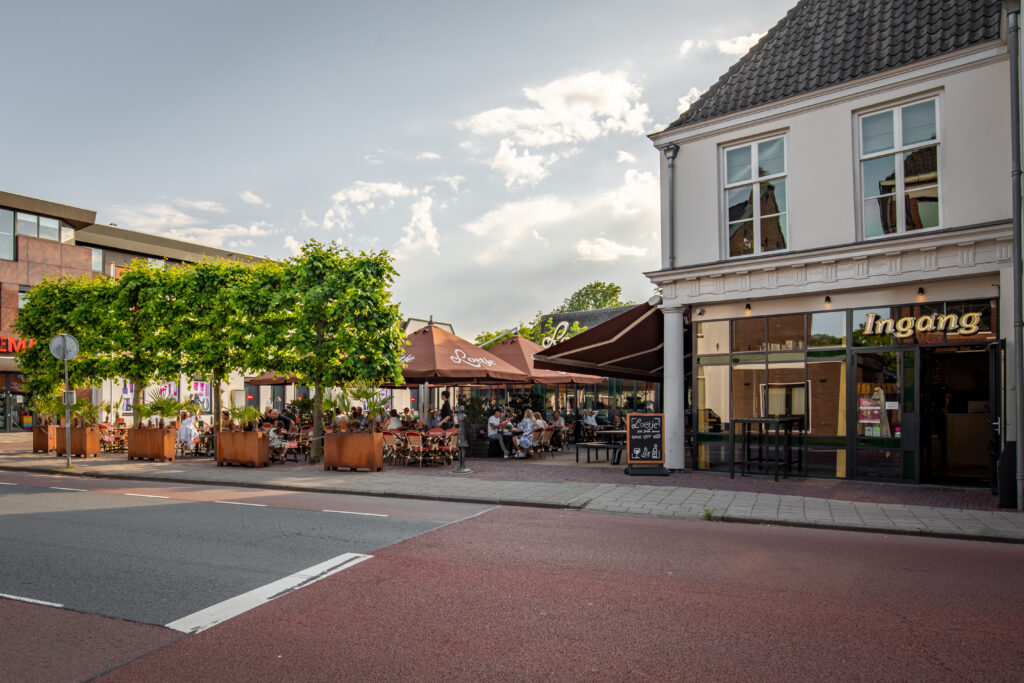 Buitenkant van Loetje Breukelen met het terras vol gasten aan de straat.