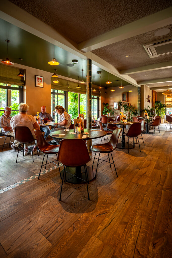 Gasten aan tafel in het warme interieur van Loetje Vught.