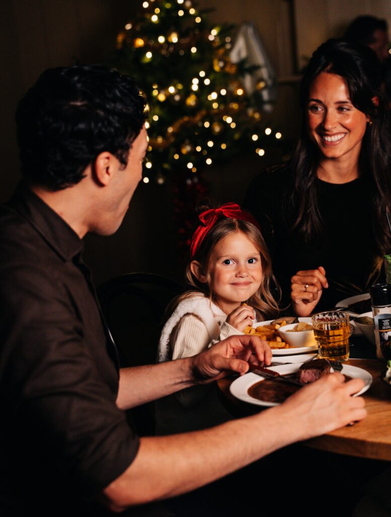 Gezin geniet van een feestelijk moment samen tijdens het kerstdiner bij Loetje
